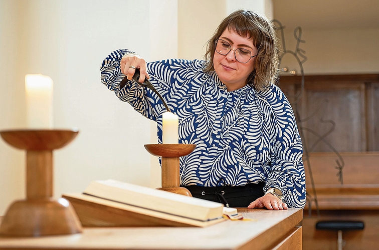Mit ruhiger Hand bringt Daniela Schneuwly die Altarkerzen zum Leuchten.Bild: Manuel Arnold