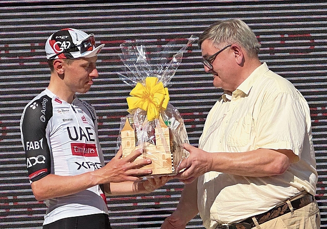 Der Aarburger Stadtpräsident Hans-Ulrich Schär (rechts) überreicht Radsportler Tadej Pogačar ein Aarburger Geschenk. Bild: Janine Müller