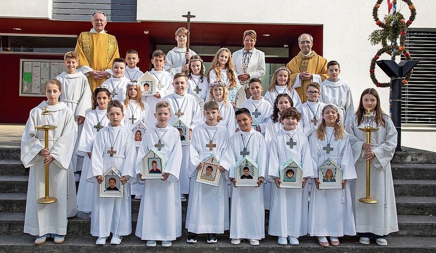 Reiden: Die 19 Erstkommunionkinder und Ministranten. In der obersten Reihe Diakon Daniel Unternährer (links), Katechetin Helene Bühler (2. von rechts) und Priester Markus Fellmann (rechts).