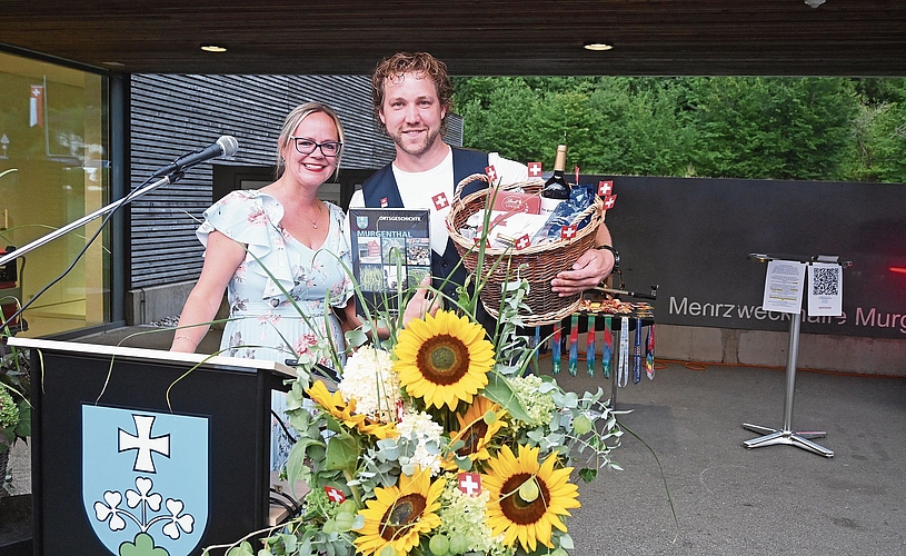 Gemeinderätin Mirjam Plüss überreicht Jan Lochbihler für seinen Auftritt einen Geschenkkorb und die Murgenthaler Ortsgeschichte. Gemeinderätin Mirjam Plüss überreicht Jan Lochbihler für seinen Auftritt einen Geschenkkorb und die Murgenthaler Ortsgeschichte.