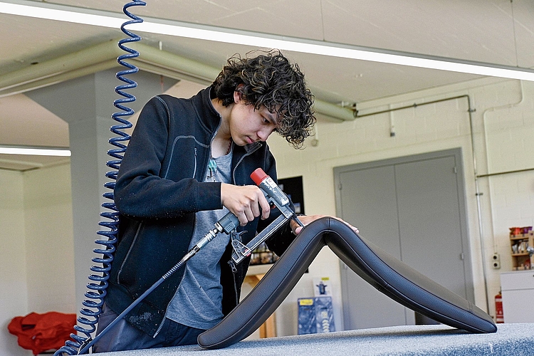 Mit der Druckpistole befestigt Aaron Sturzenegger die Leder und Stoffe an der richtigen Stelle. Mit der Druckpistole befestigt Aaron Sturzenegger die Leder und Stoffe an der richtigen Stelle.