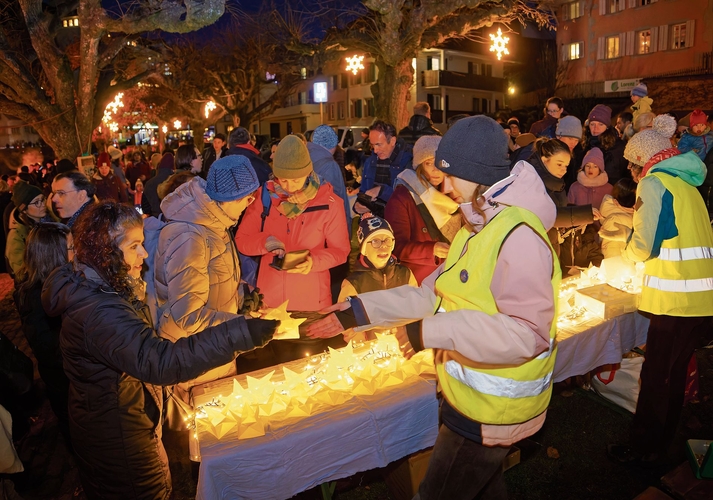 Helfende verkaufen die Lichtschiffchen.