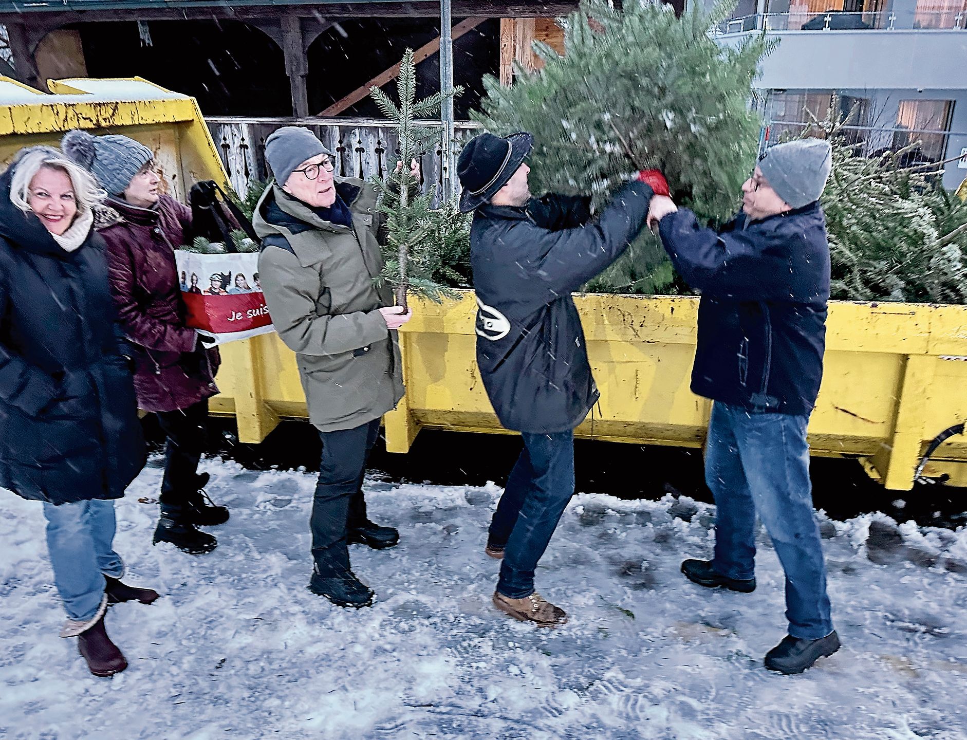Gut gelaunte Menschen werden beim Entsorgen des Weihnachtsbaumes von Helfern des Feuerwehrvereins Oftringen unterstützt.Bilder: Jil Lüscher