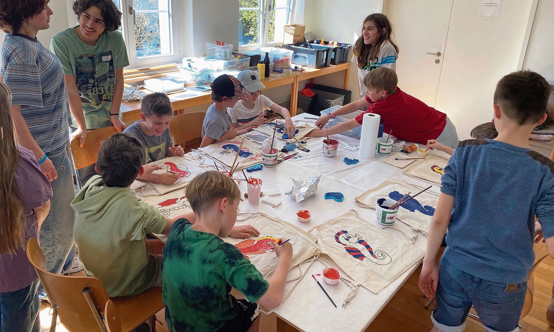 Eifrig werden Stofftaschen bemalt.